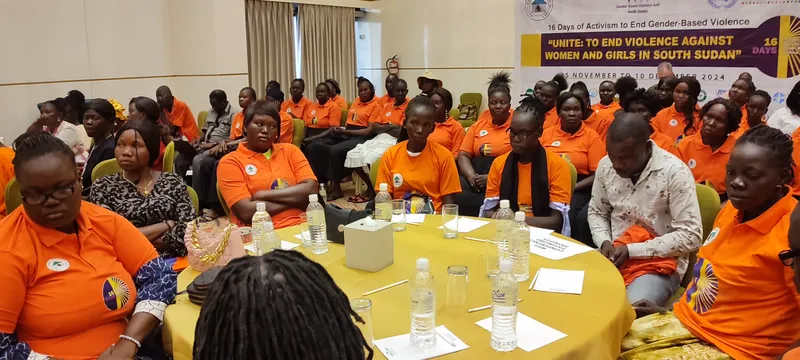 Participants beneath a banner reading "Unite to end violence against women and girls in South Sudan"